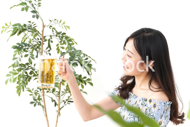 ビアガーデンでビールを飲む若い女性