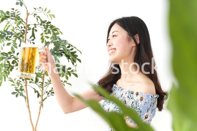 ビアガーデンでビールを飲む若い女性