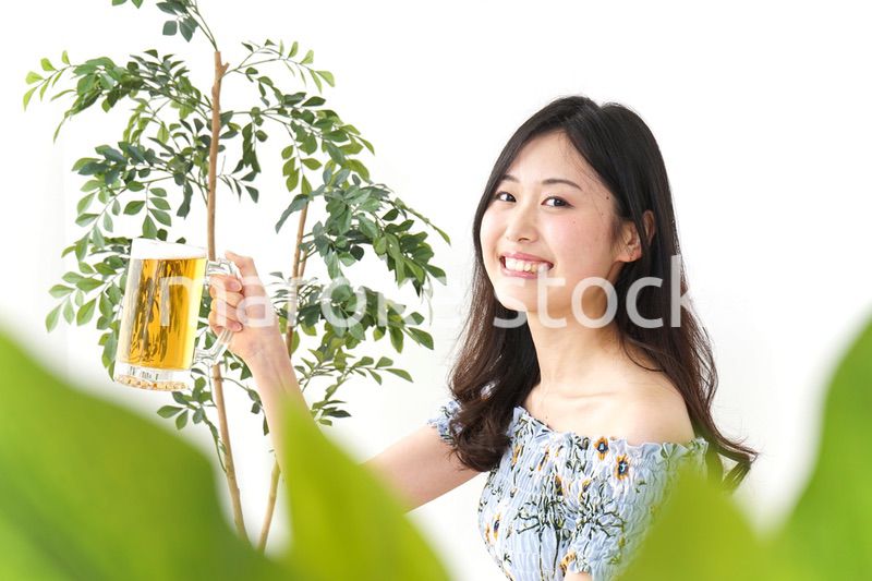 ビアガーデンでビールを飲む若い女性