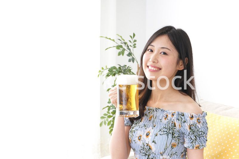 自宅でビールを飲む女性
