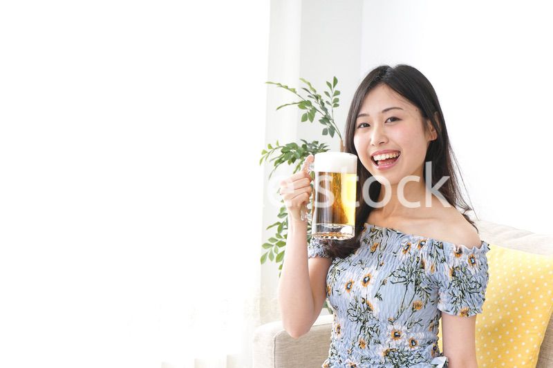 自宅でビールを飲む女性
