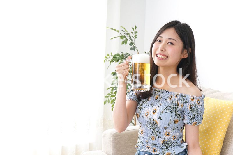 自宅でビールを飲む女性