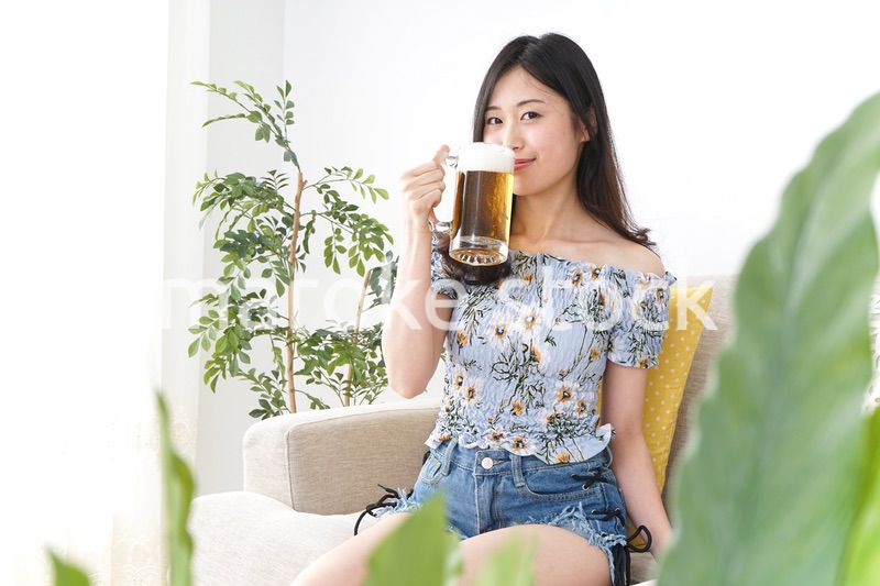 自宅でビールを飲む女性