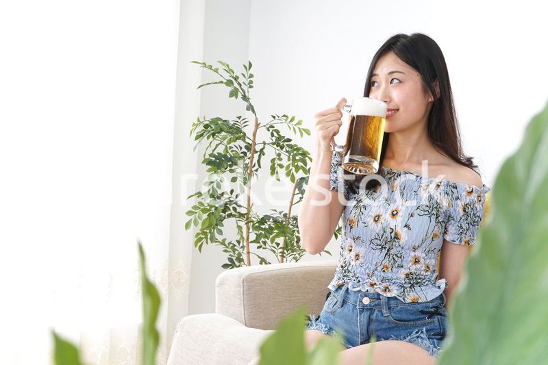 自宅でビールを飲む女性
