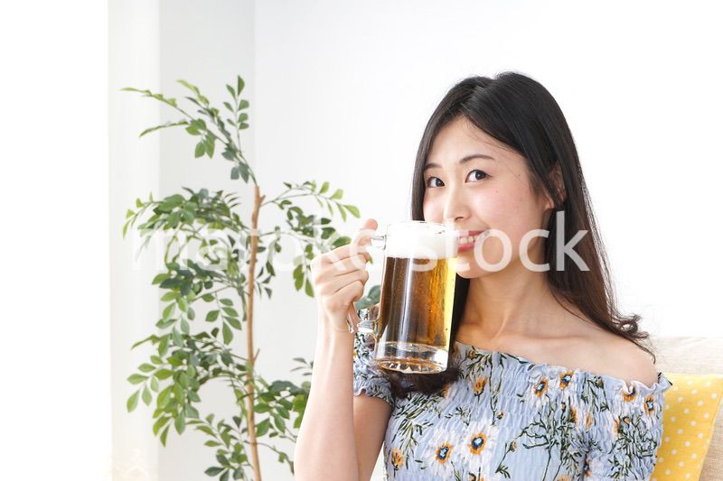 自宅でビールを飲む女性