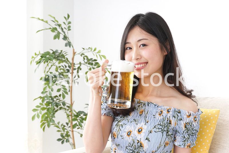 自宅でビールを飲む女性