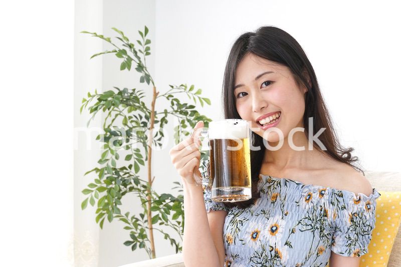 自宅でビールを飲む女性