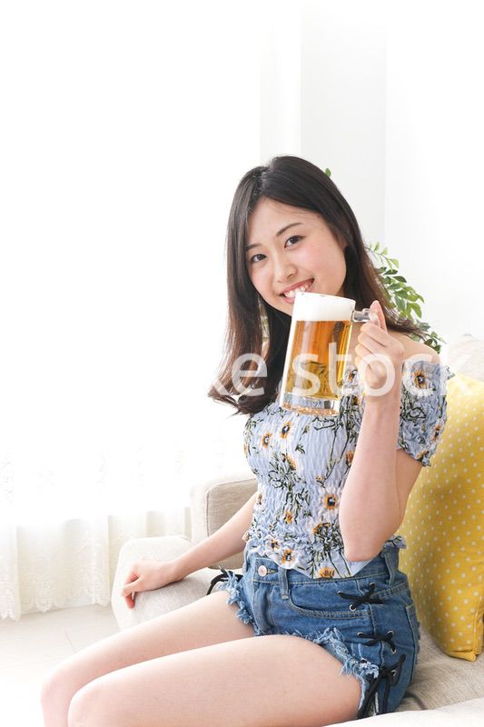 自宅でビールを飲む女性