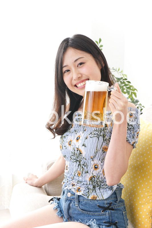自宅でビールを飲む女性
