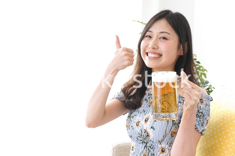自宅でビールを飲む女性