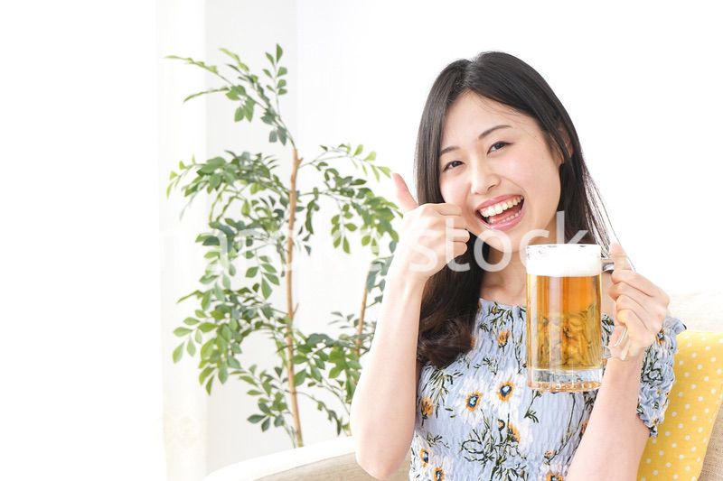 自宅でビールを飲む女性