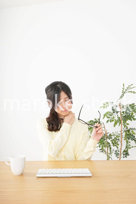 オフィスワークで疲れた若い女性