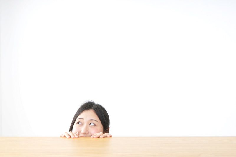 テーブルから顔を出す女性