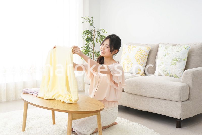 洗濯物をたたむ若い女性