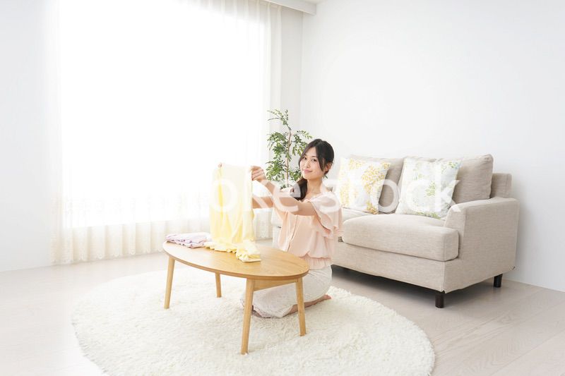 洗濯物をたたむ若い女性