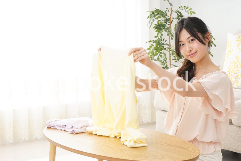 洗濯物をたたむ若い女性