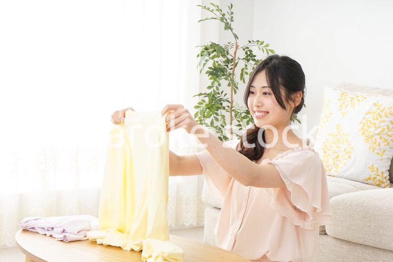 洗濯物をたたむ若い女性