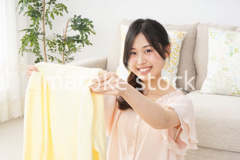 洗濯物をたたむ若い女性