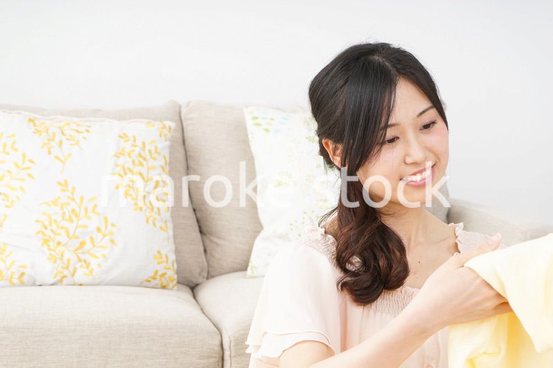 洗濯物をたたむ若い女性