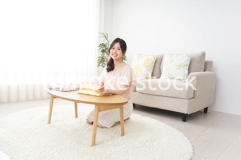 洗濯物をたたむ若い女性