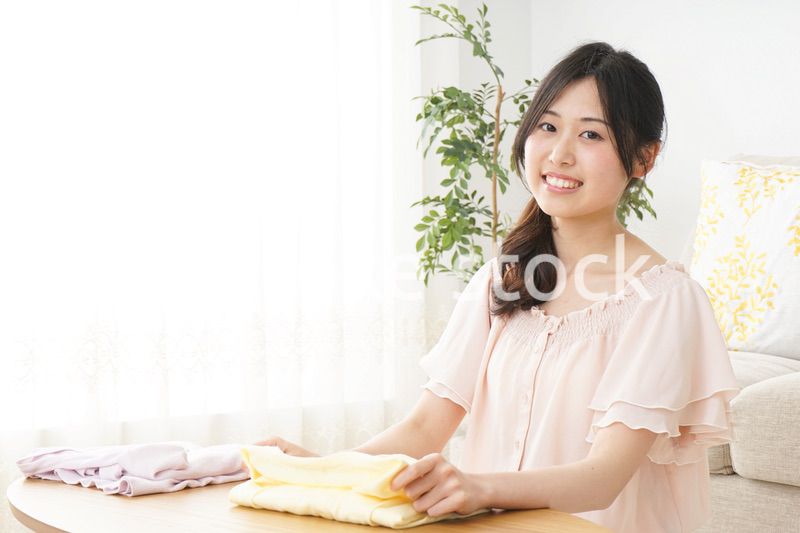洗濯物をたたむ若い女性