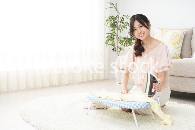 アイロンがけをする若い女性