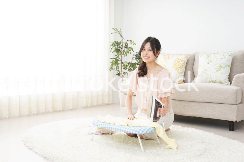 アイロンがけをする若い女性