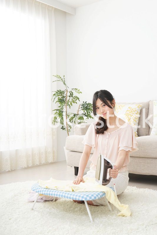 アイロンがけをする若い女性