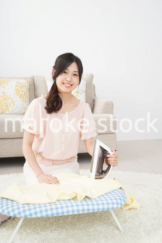 アイロンがけをする若い女性