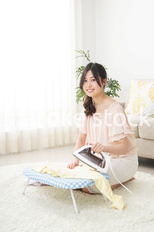 アイロンがけをする若い女性