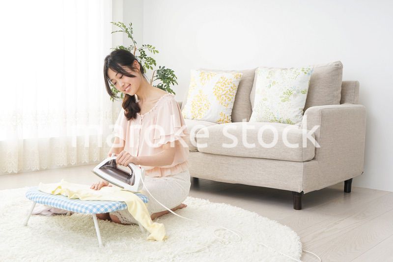 アイロンがけをする若い女性