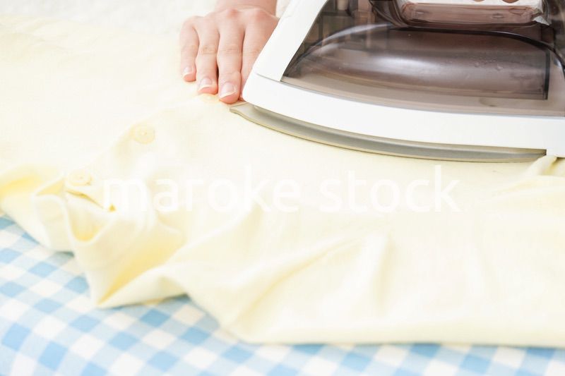 アイロンがけをする若い女性