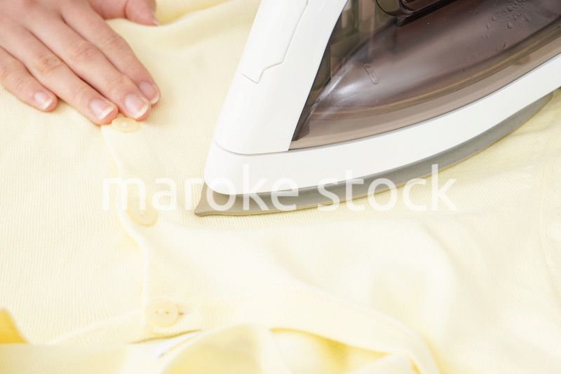 アイロンがけをする若い女性