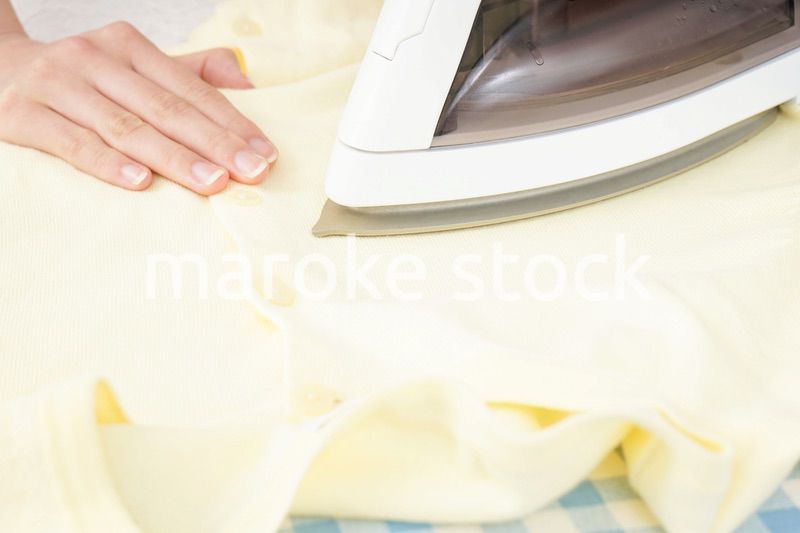 アイロンがけをする若い女性