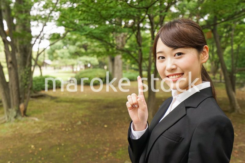 上を指さすビジネスウーマン