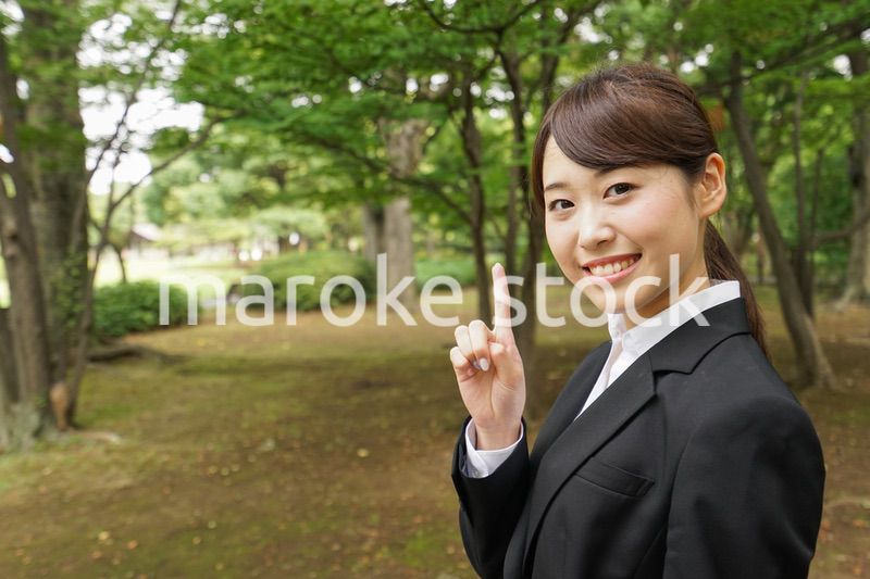 上を指さすビジネスウーマン