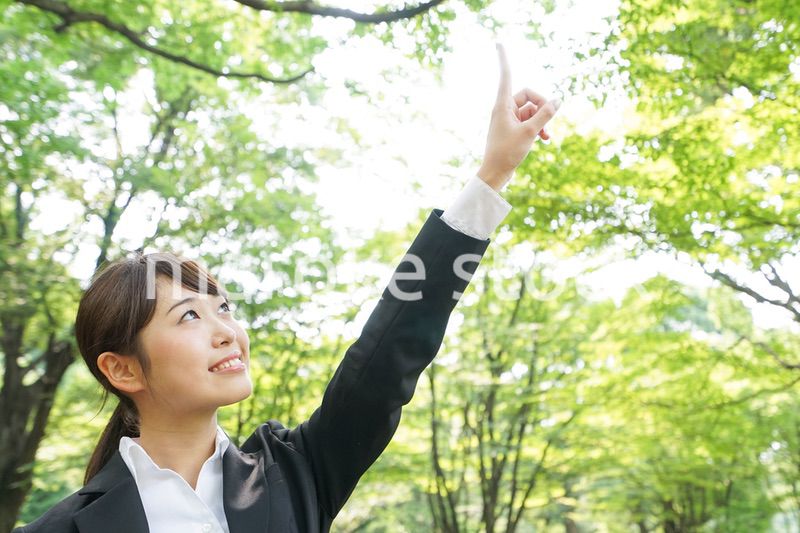 上を指さすビジネスウーマン