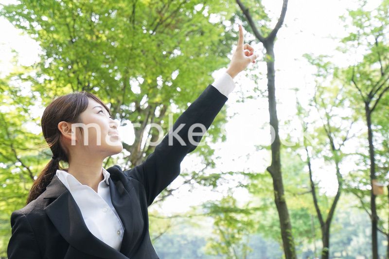 上を指さすビジネスウーマン
