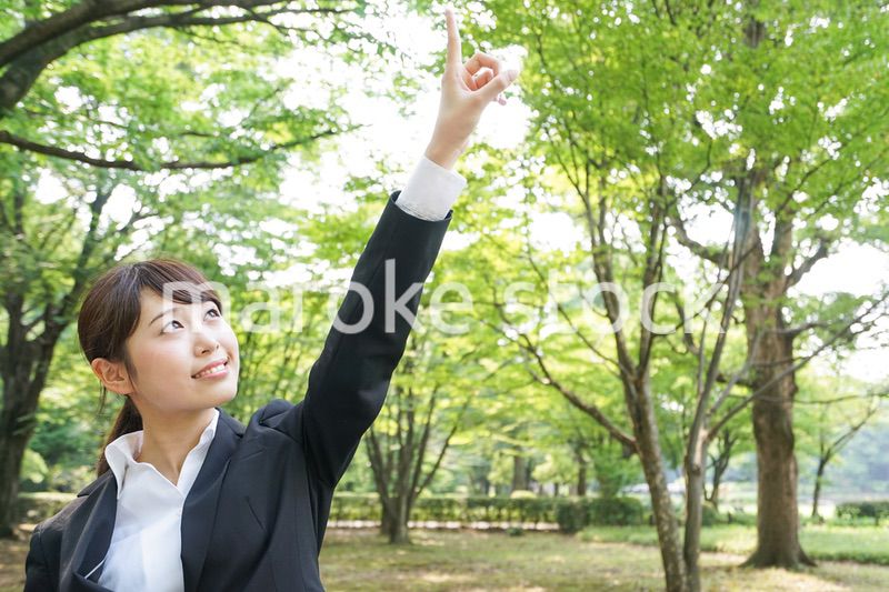 上を指さすビジネスウーマン