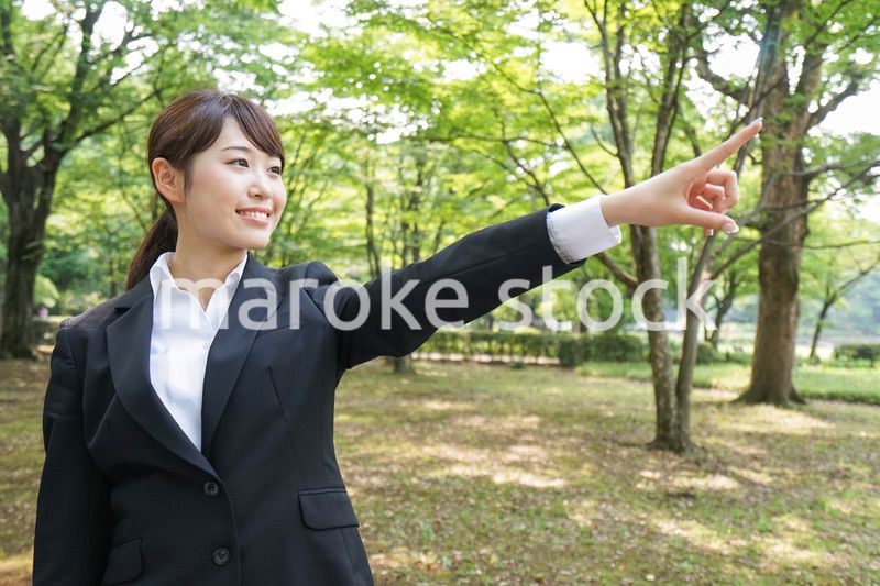 上を指さすビジネスウーマン