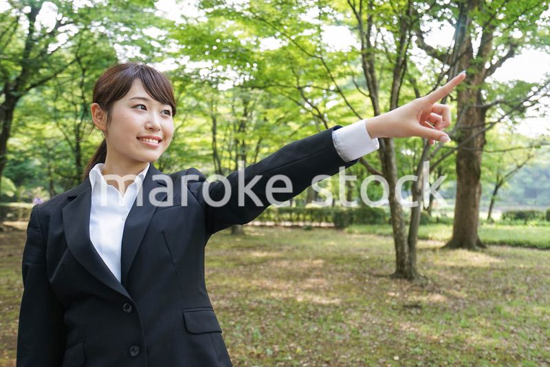 上を指さすビジネスウーマン