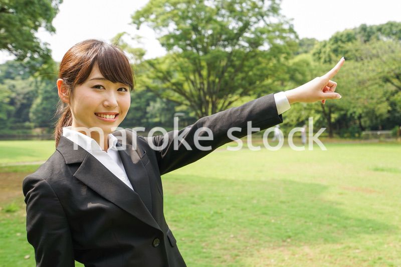 上を指さすビジネスウーマン