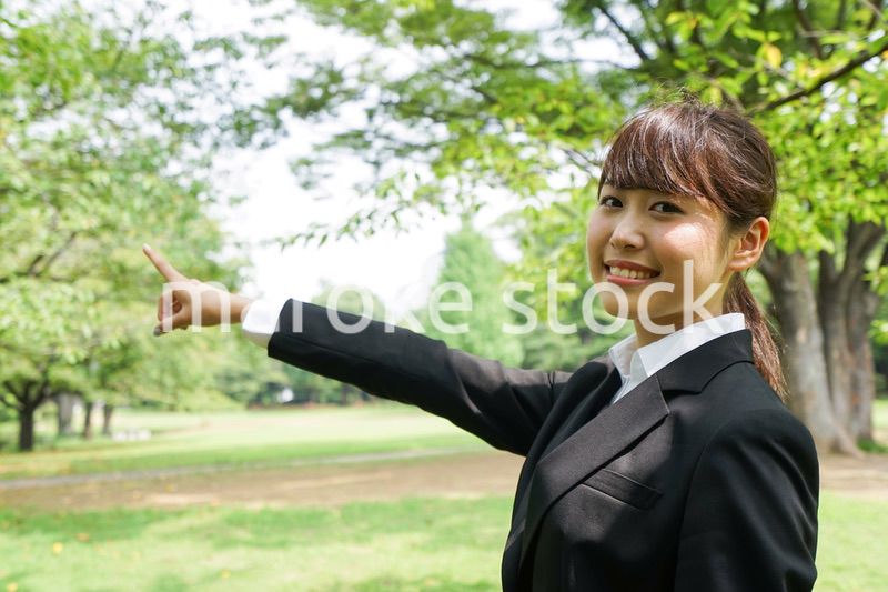 上を指さすビジネスウーマン