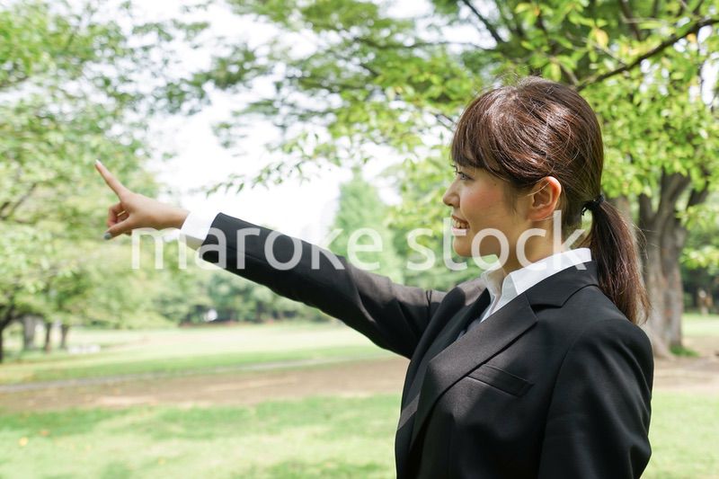 上を指さすビジネスウーマン