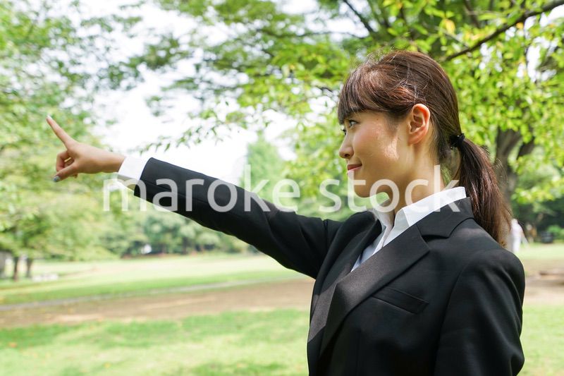 上を指さすビジネスウーマン