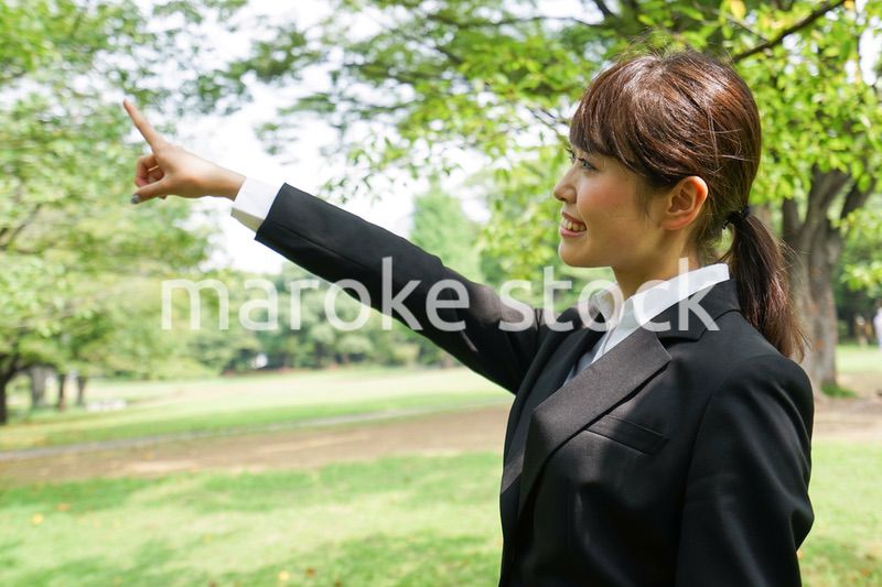 上を指さすビジネスウーマン