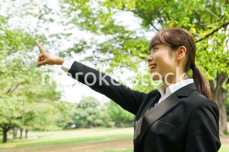 上を指さすビジネスウーマン