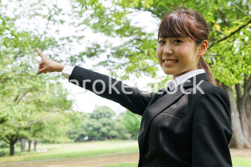 上を指さすビジネスウーマン