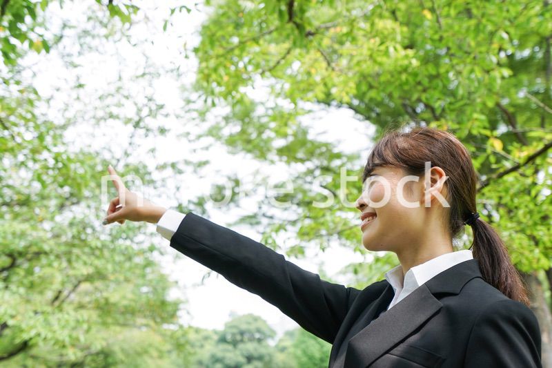 上を指さすビジネスウーマン