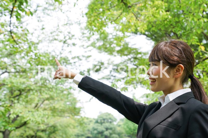 上を指さすビジネスウーマン